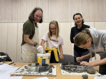 a group of young people working with casting material to make sculpture.